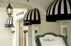 an entrance to a building with black and white striped awnings