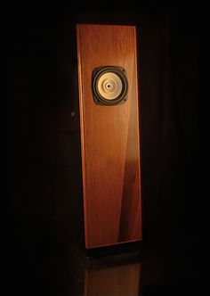 a wooden speaker in the dark with its light on