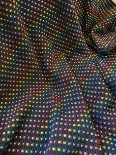 the fabric is multicolored and has small dots on it, as well as a black background