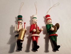 three wooden nutcrackers are hanging from strings