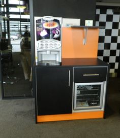 an orange and black oven sitting on top of a counter next to a checkered wall