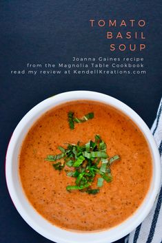 tomato basil soup in a white bowl on a blue and white towel