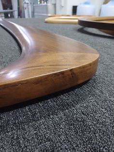 a wooden surfboard laying on top of a carpeted floor