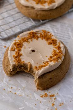 two cookies with white frosting and orange sprinkles