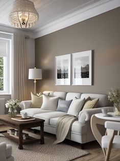 a living room filled with furniture and a chandelier hanging above the couches