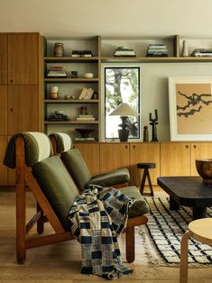 a living room filled with furniture next to a wooden table and bookshelf on top of a hard wood floor