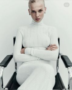 a woman sitting in a chair with her arms crossed