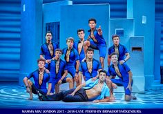 a group of men in blue swimsuits posing for a photo on the stage