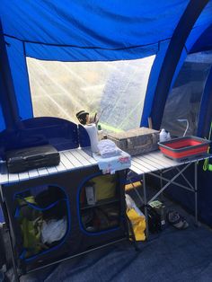 the inside of a tent with blue walls and shelves filled with items on top of it