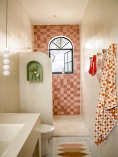 a bathroom with a sink, toilet and towel rack on the wall next to it