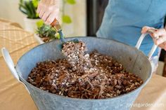 a person is scooping out some food into a bucket