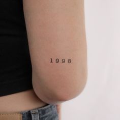 a woman with a small tattoo on her left arm that reads,'1989 '