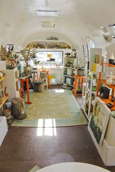 the inside of an art studio with lots of shelves and pictures on display in it