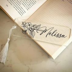 an open book with a tassel on top of it