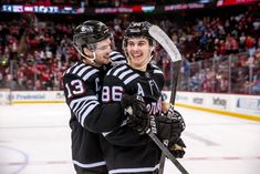 two hockey players hugging each other on the ice