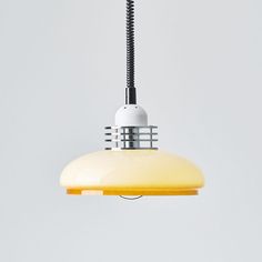 a yellow light hanging from a ceiling with a black cord attached to the end of it