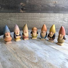 seven little gnomes sitting on top of a wooden table