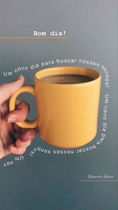 a person holding a yellow coffee cup in their right hand with the words bonn dia on it