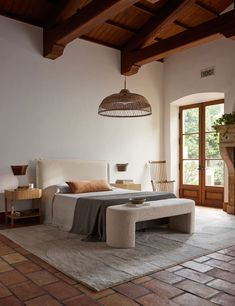 a bedroom with a large bed and stone flooring