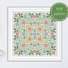 a cross - stitch pattern with scissors and thread on the table, next to it is a