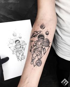 a tattoo on the arm of a man that has an astronaut and planets on it