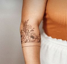 a woman's arm with a flower tattoo on the left side of her arm