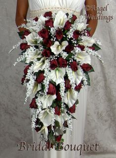 a bridal bouquet with red roses and white calla lilies in the center