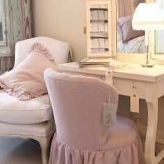 a chair and desk with a mirror on it in a room that has been decorated