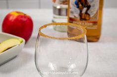 an apple and some wine glasses on a table