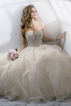 a woman in a wedding dress sitting on the floor