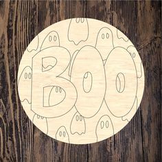 a wooden plate with the word boo spelled out in ghosty font on top of it