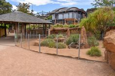 a fenced in area with rocks and plants