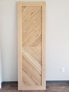 an open wooden door in the corner of a room with wood flooring and white walls