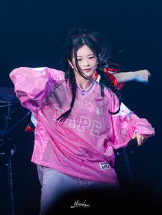 a woman with long hair wearing a pink shirt