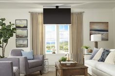 a living room filled with furniture and a window covered in shades of blue, grey and white