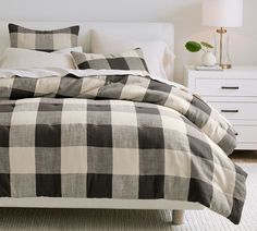 a black and white checkered comforter on a bed in a room with two nightstands