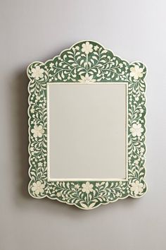 a green and white mirror hanging on the wall