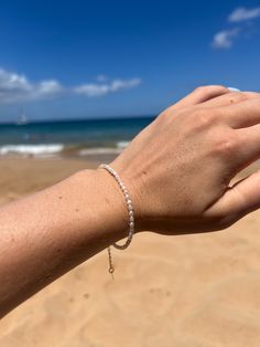 This is a handmade by me, teeny tiny freshwater pearl bracelet...made with exquisite tiny 2-3mm rice pearls. This sweet bracelet is dainty and delicate.  Simple and classic. All components are gold-fill and can be worn in water. Pearls are genuine freshwater AA pearls.  Sizing in inches.  6.0. Xtra small  6.5 Small 7.0 Medium 7.5 Large Handmade with gold beading wire that will hold its shape but not feel rigid. Gold-fill lobster clasp and extender chain. Comes with jewelry care card to maximize