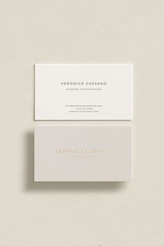 two white business cards sitting on top of each other