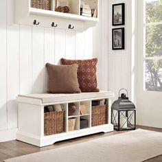 a white bench with some baskets on it and a lantern in the corner next to it