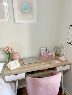 a pink chair sitting next to a desk with a laptop on top of it in a bedroom