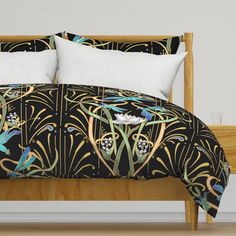 a bed with black and gold designs on the comforter, pillows and pillow cases