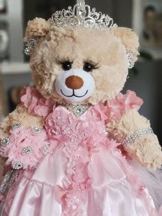 a teddy bear wearing a pink dress and tiara