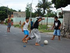 several young men playing soccer on the street