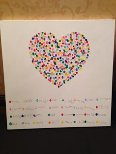 a heart made out of many different colored dots on a white paper with writing underneath