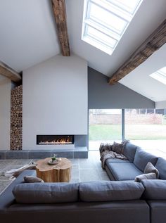 a living room with a couch, coffee table and fire place in the middle of it