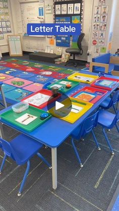 a classroom with tables, chairs and pictures on the wall that says letter table in front of them