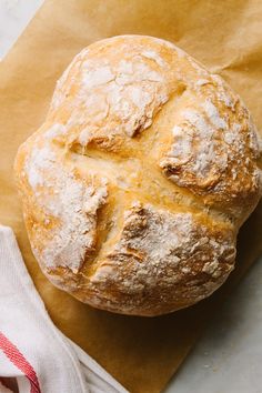 a loaf of bread sitting on top of a piece of paper next to a napkin