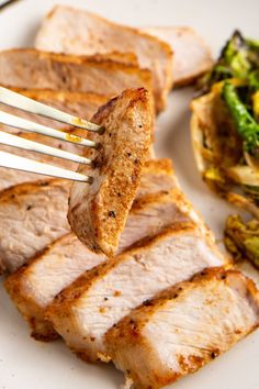 a plate with meat, broccoli and some kind of sauce on it that is being held up by a fork