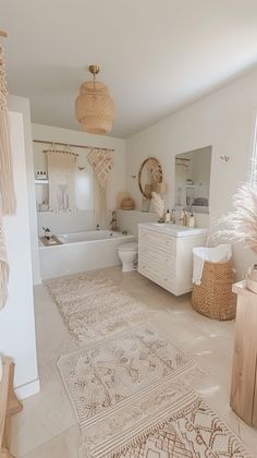 a white bathroom with rugs on the floor